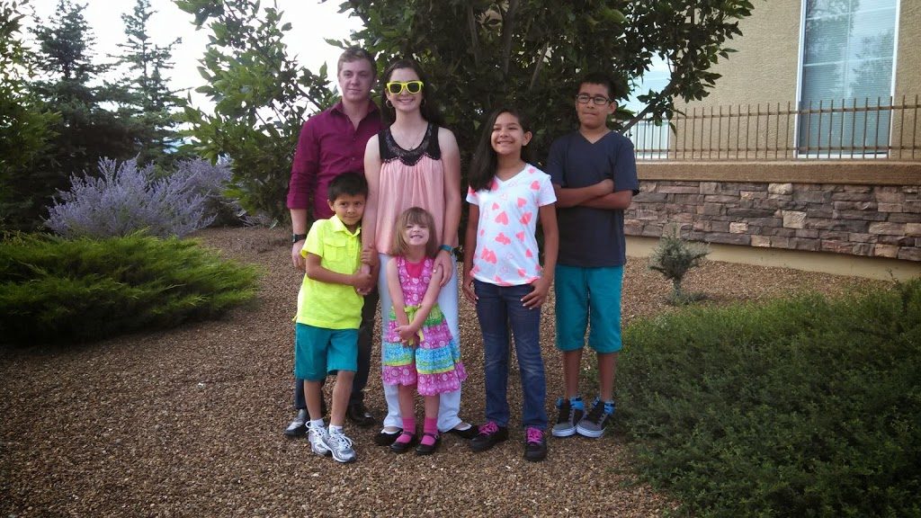 A family posing for a picture in front of a house.