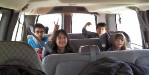 A group of kids sitting in a van.