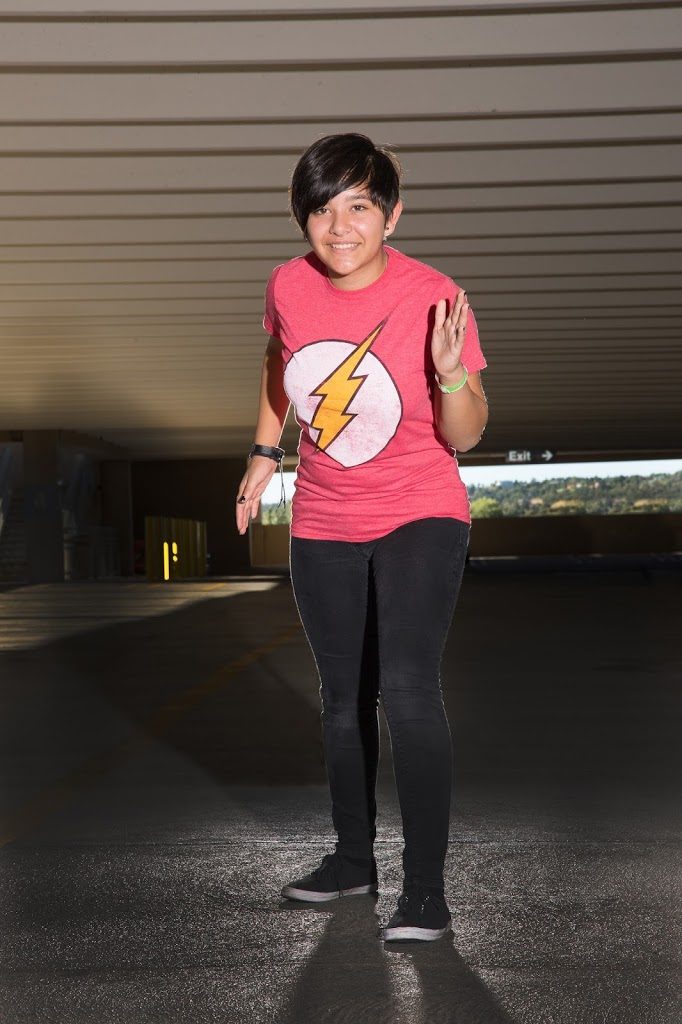 A woman wearing a flash t - shirt in a parking garage.