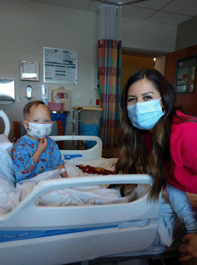 small boy with down syndrome wearing a hospital mask winning the heart of his nurse in the hospital