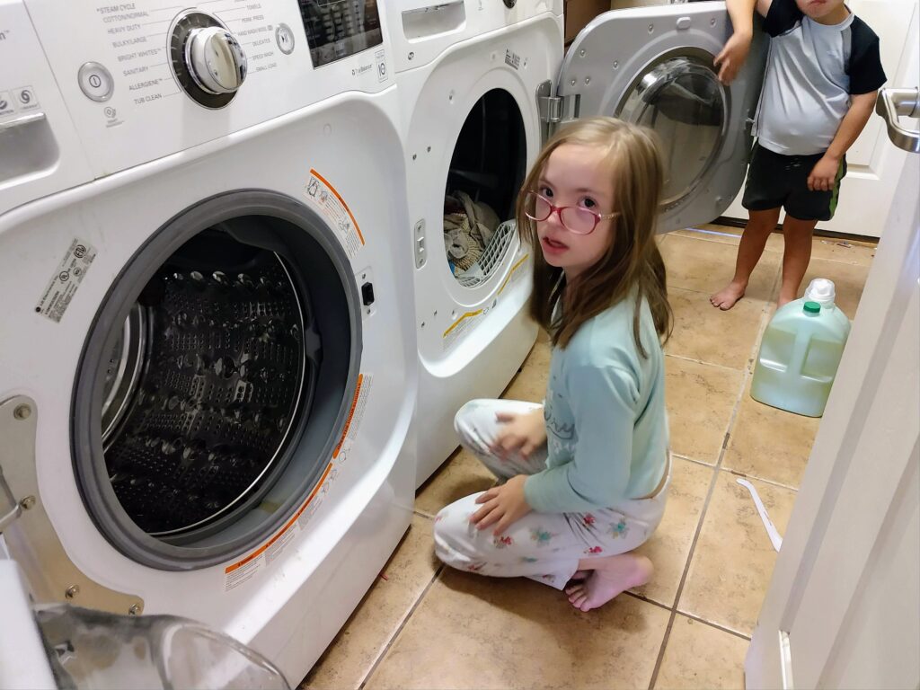 Children using the washer and dryer together as part of a family laundry routine.