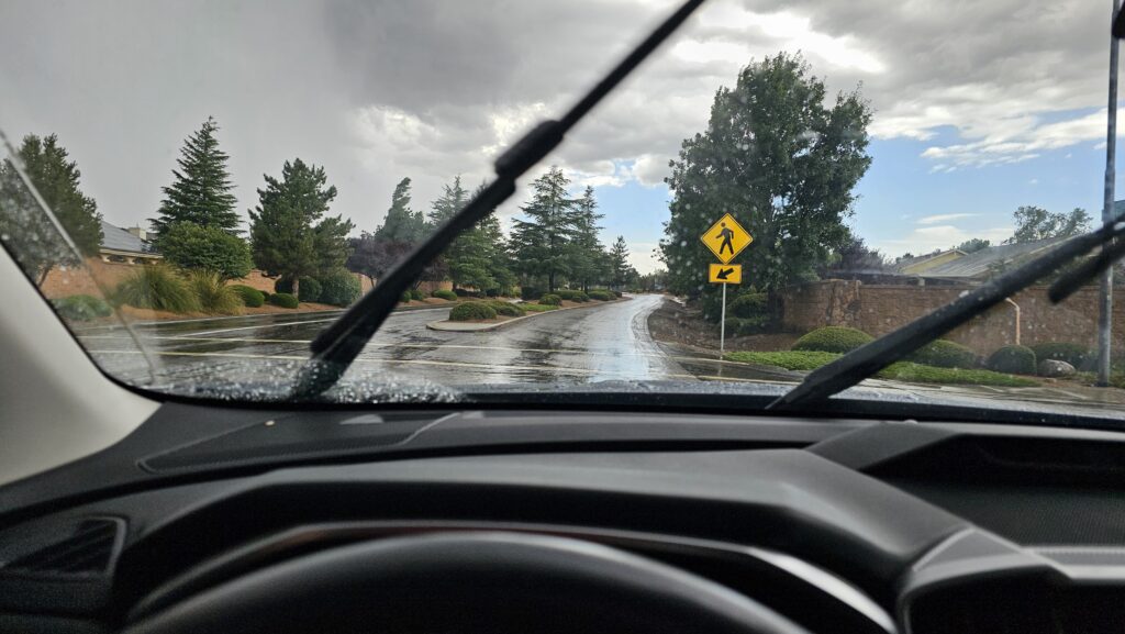 View through a car windshield on a rainy road, symbolizing uncertainty, transition, and trusting God to lead the way forward.