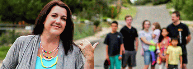 A mother standing in the foreground with her family behind her, symbolizing leadership, faith, and guiding a family through a season of change.