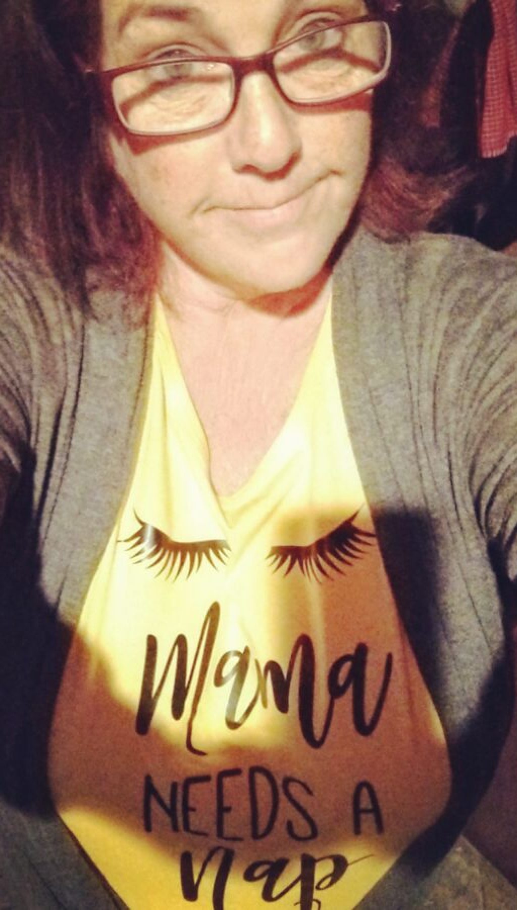 Selfie of middle aged woman with yellow shirt that has "Mama Needs a Nap" on it